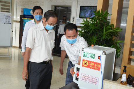 Thầy Bùi Đình Ninh - Phó Hiệu trưởng, Chủ tịch CĐ trường giới thiệu với Chủ tịch HĐQT VRG vận hành của máy rửa tay. Ảnh: Vũ Phong.